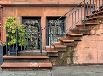 New York City brownstone exterior representing factors insurance companies review before quoting landlord insurance